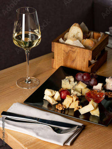 Glass of wine with appetiser on table in restaurant interior background. Italian and French food style for menu