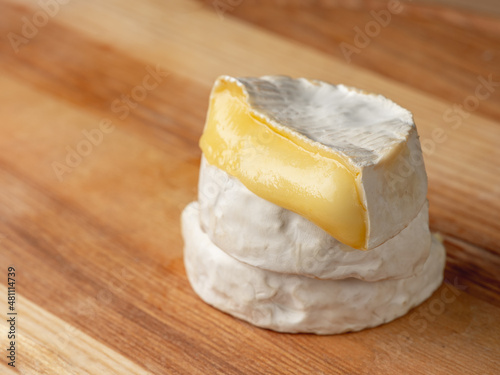 French cheese camembert or brie close up on wooden table. Food ingredient for snack, starter or appetiser 