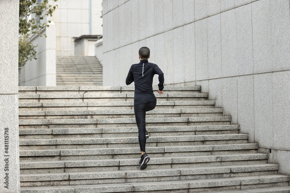 Fitness woman running up stairs in city