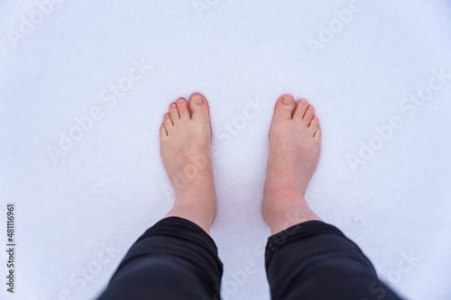 Nackte Füße von einer Frau im Schnee. Draufsicht, Kälte, Winter.