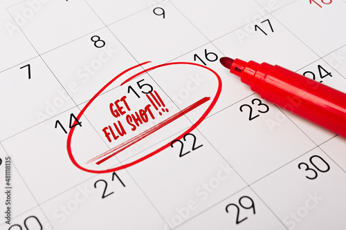 text - Get Flu Shot - written on calendar for remind. Closeup of a personal agenda