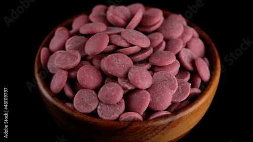 Ruby chocolate chips in wooden bowl. Confectionery concept