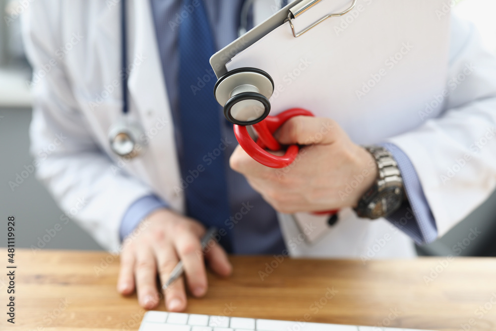 Doctor holding medical equipment red stethoscope and patient medical history