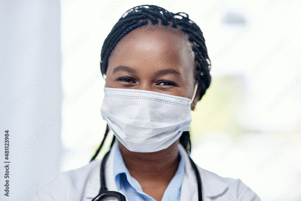 Serving on the frontlines. Portrait of a young doctor wearing a face mask while working in a hospital.