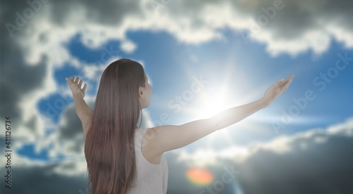 Young woman looking up feeling energized by the warm rays and sky