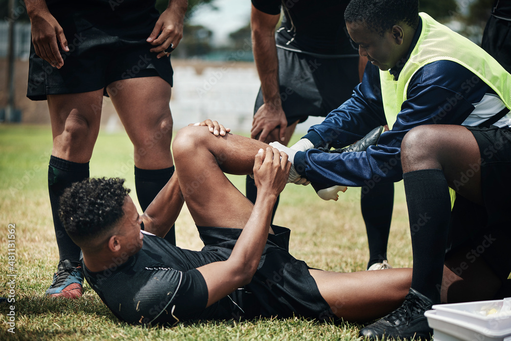 Let me help you with that. Cropped shot of a young rugby player receiving first aid assistance on the field. Let me help you with that. Cropped shot of a young rugby player receiving first aid assistance on the field.