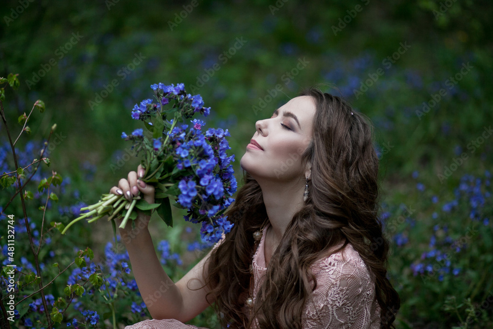 A young girl walks in a field of blue flowers at dusk. A young girl walks in a field of blue flowers at dusk.