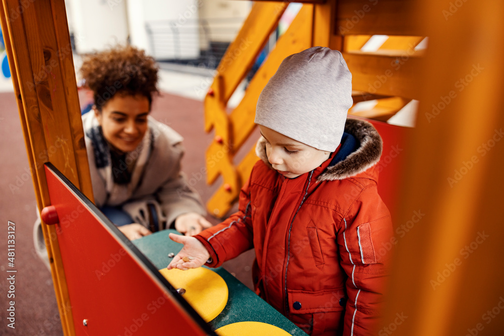 Little boy playing games at the playground with his babysitter. Little boy playing games at the playground with his babysitter.