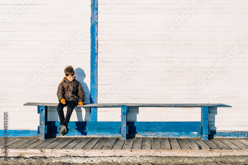 Autism awareness concept. Autism boy sits alone on a blue bench