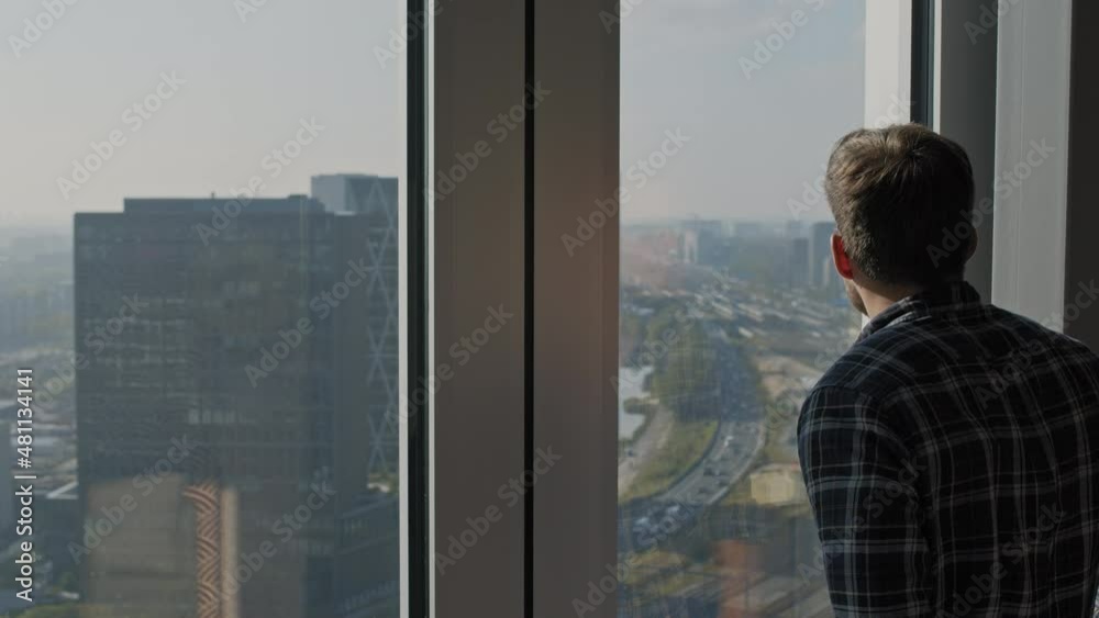 person looking through window highway with city in the back