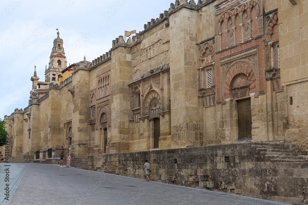 Exterior facade view at Mosque-Cathedral of Córdoba, or Cathedral of Our Lady of the Assumption, Roman Catholic Diocese of Córdoba, tourist people strolling, downtown city