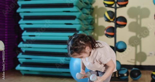 Healthy lifestyle. Mom and daughter are doing strength exercises with dumbbells.