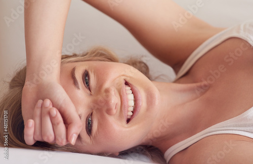 Start your day with a smile. Portrait of a beautiful young woman lying on her bed.