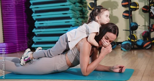 Mom and daughter hold the plank. Sport family.