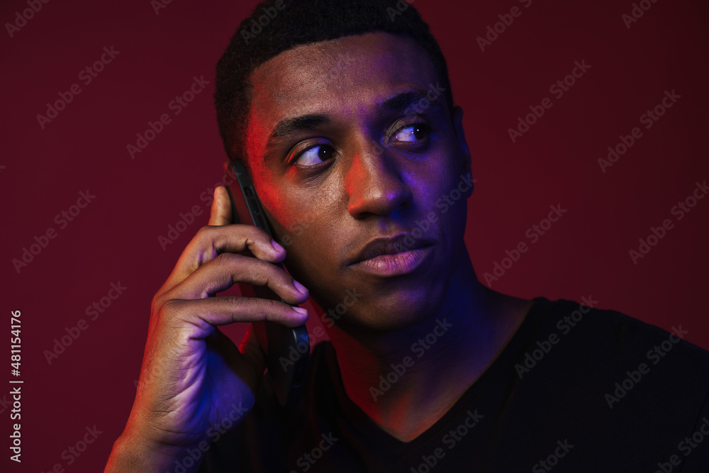 Young black man in t-shirt talking on mobile phone