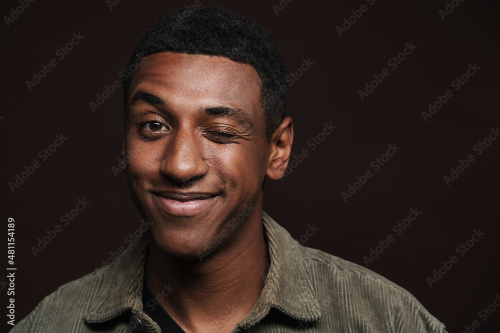 Young black man dressed in shirt smiling and winking at camera Young black man dressed in shirt smiling and winking at camera