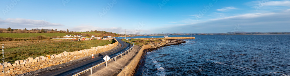 Coastal road and pier next to the Atlantic in Mountcharles in County Donegal - Ireland.