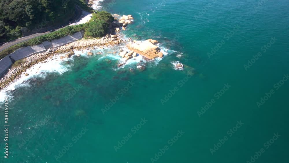 リアス式海岸のーに打ち寄せる波と道路を走る車をドローン空撮 リアス式海岸のーに打ち寄せる波と道路を走る車をドローン空撮