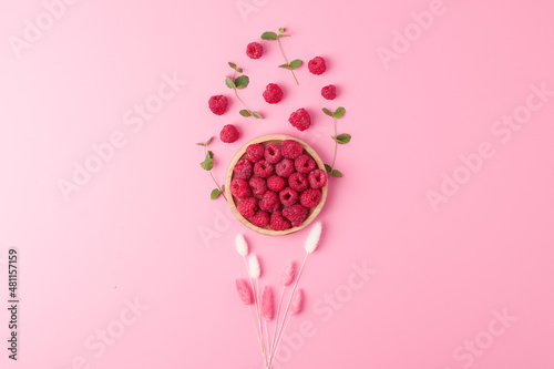 Creative summer background made from fresh berries and flowers on pink. Flat lay, copy space.