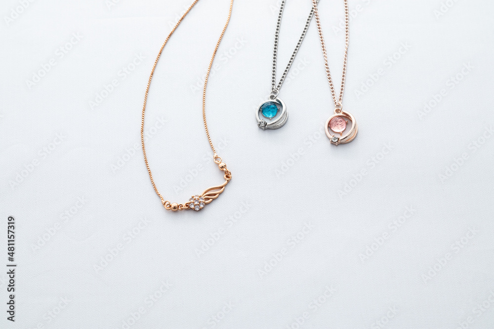 Silver chain necklaces with blue and red diamond pendant on white background Silver chain necklaces with blue and red diamond pendant on white background