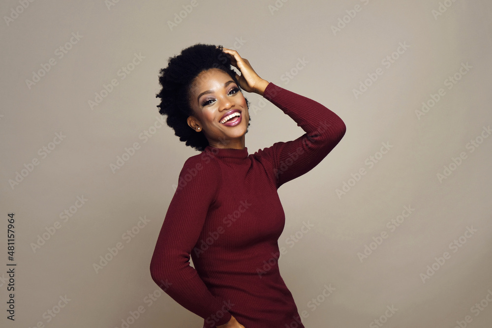Cheerful smiling black woman with curly hairstyle dancing against gray background. Cheerful smiling black woman with curly hairstyle dancing against gray background.