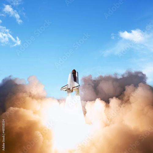 Fototapeta Naklejka Na Ścianę i Meble -  Successful start of a space mission, concept. Shuttle rocket with clouds of smoke takes off into the blue sky