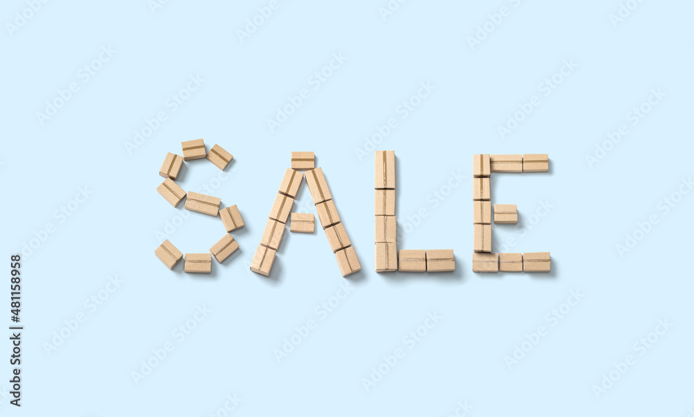 Word SALE made from cardboard boxes on blue background Word SALE made from cardboard boxes on blue background