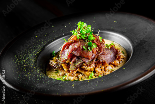 Fototapeta Naklejka Na Ścianę i Meble -  Spelt with meat in black plate