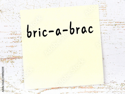 Yellow sheet of paper with word bric-a-brac. Reminder concept photo