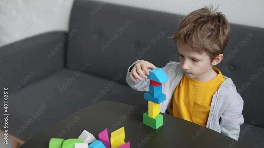 Little boy building constructor of wooden blocks at home, enjoying development activities. Slow motion Little boy building constructor of wooden blocks at home, enjoying development activities. Slow motion