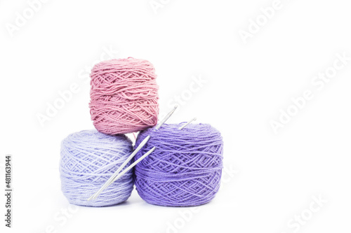 Ovillos de lana con agujas para tejer sobre un fondo blanco liso y aislado. Vista de frente y de cerca. Copy space photo