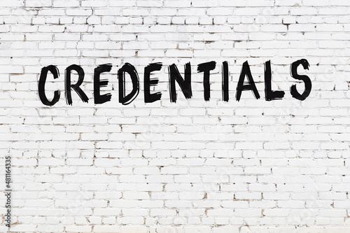 White wall with black paint inscription credentials on it