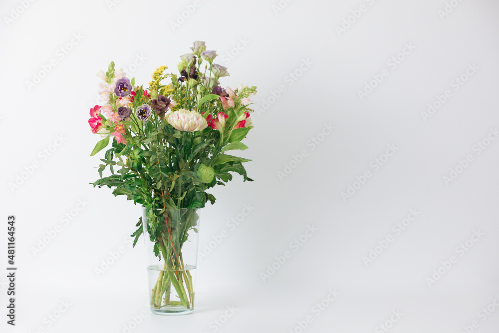 Fototapeta premium Beautiful bouquet of flowers in a vase. Bouquet of chrysanthemum, alstroemeria, goldenrod, snapdragon, lisianthus and eucalyptus parvifolia. bouquet of flowers on white background. 