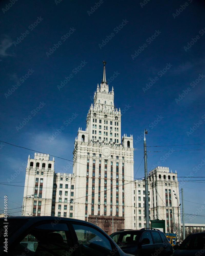 The High-rise building of Ministry of Foreign Affairs of Russia in Moscow. Direct sunlight, dark blue sky. One of Stalinist skyscrapers. Dark cars on foreground.