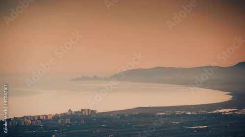 View down to the sea coast and Alcossebre seaside village from the Hermitage of Saint Lucia. Valencian Community, Costa del Azahar, province of CastellĂł, Spain. photo