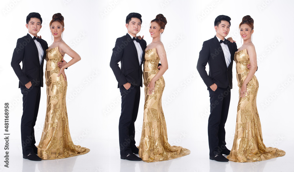 Two couple Full length of man in black suit tie and woman in gold long ...