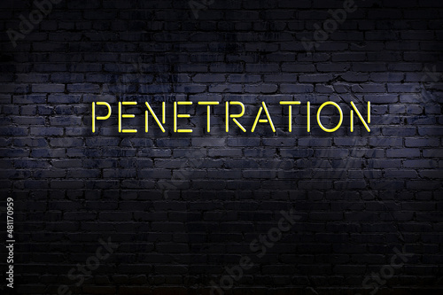 Neon sign. Word penetration against brick wall. Night view photo