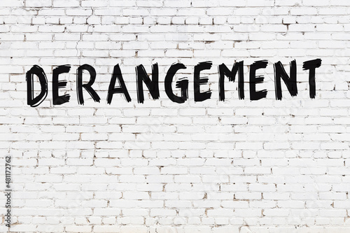 White wall with black paint inscription derangement on it