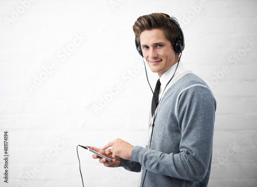 Managing his playlist. A young nerdy guy holding an mp3 player. photo