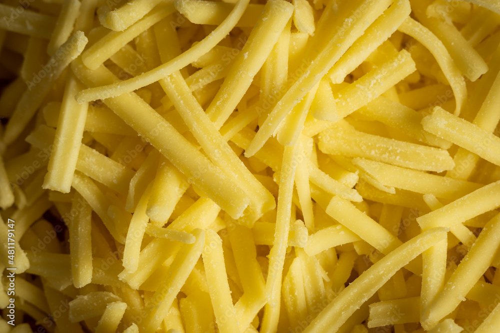 grated cheddar cheese background closeup grated cheddar cheese background closeup
