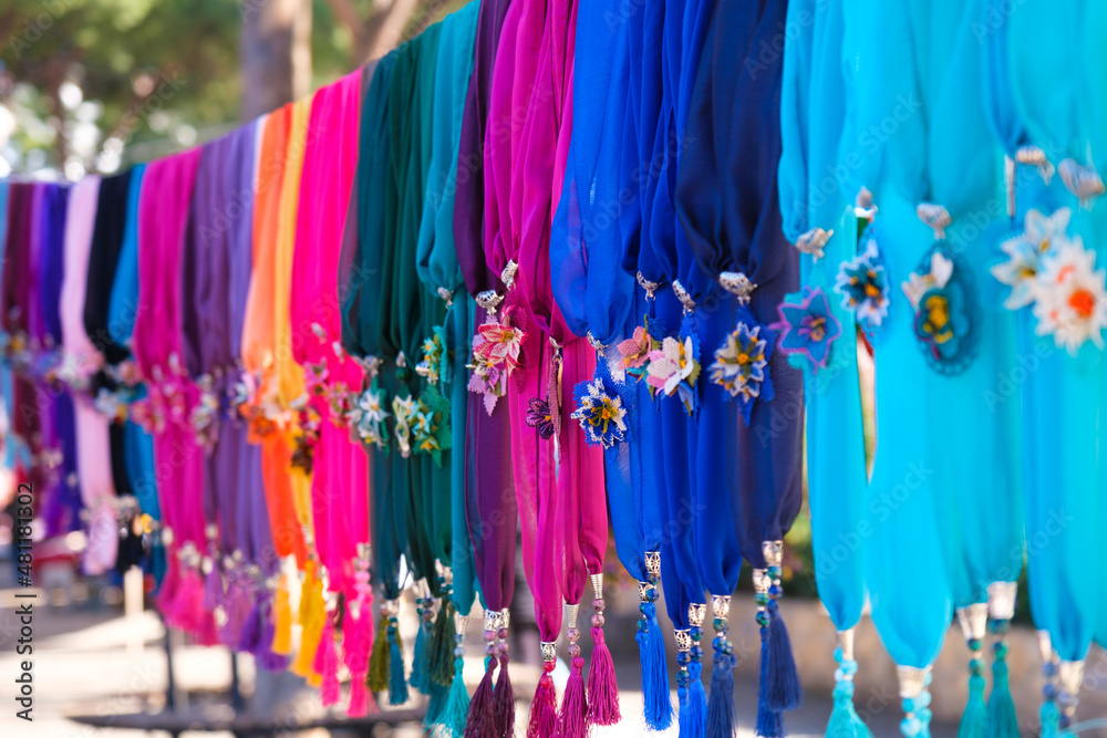 Colorful handmade scarves lined up on a rope hanger in woman producer  bazaar in Odemis, Izmir.