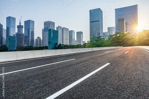 Asphalt road and city skyline with modern commercial office buildings in Shenzhen at sunrise  China.