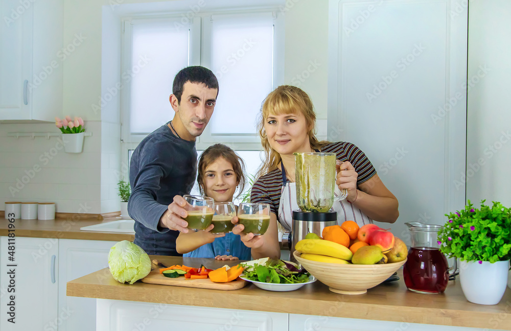 The family is making smoothies in the kitchen. Selective focus.