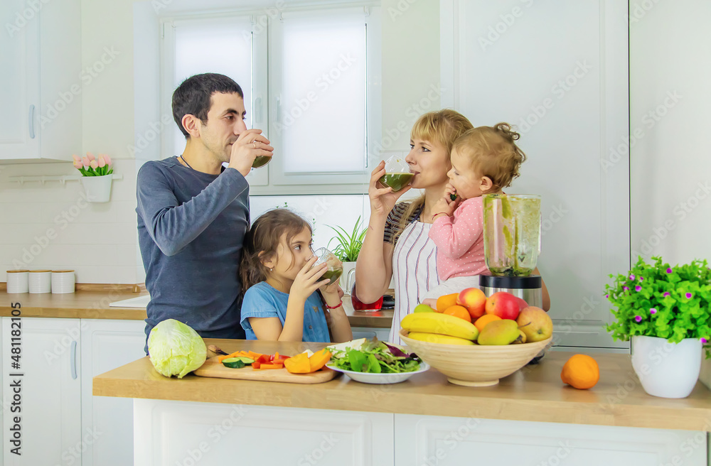 The family is making smoothies in the kitchen. Selective focus. The family is making smoothies in the kitchen. Selective focus.