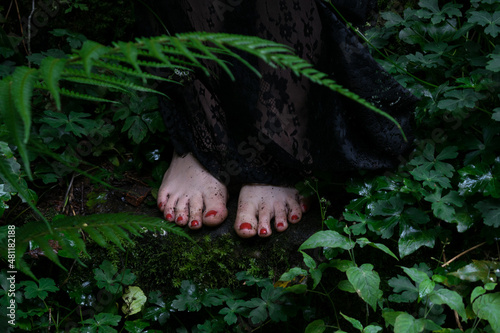 Close-up of a woman standing barefoot in a forest, Spain photo