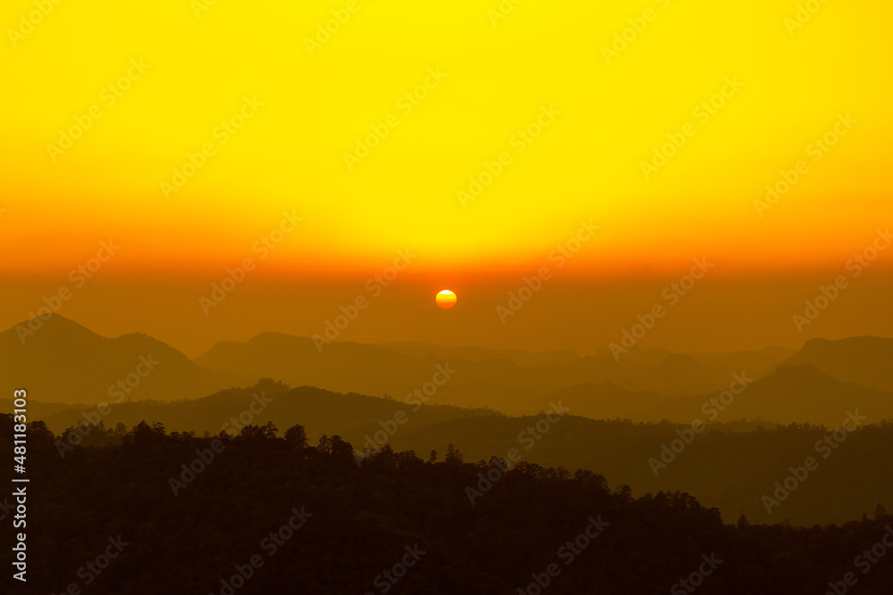 Landscape photo of sunset over clouds with mountain hill forest. in golden or warm light tone.