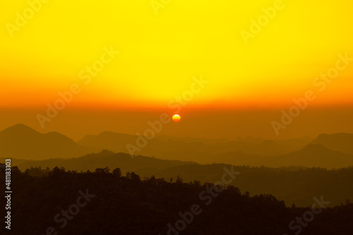 Landscape photo of sunset over clouds with mountain hill forest. in golden or warm light tone.