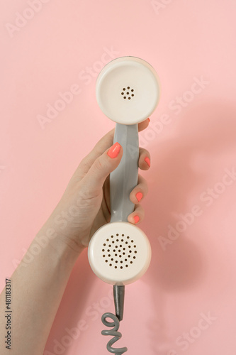 Wallpaper Mural Vintage scene with female hand scrolling retro phone receiver. Minimal composition on pastel pink background. Top view. Torontodigital.ca