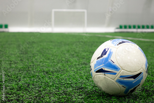 A soccer ball placed on a green grass lawn with a copy space.