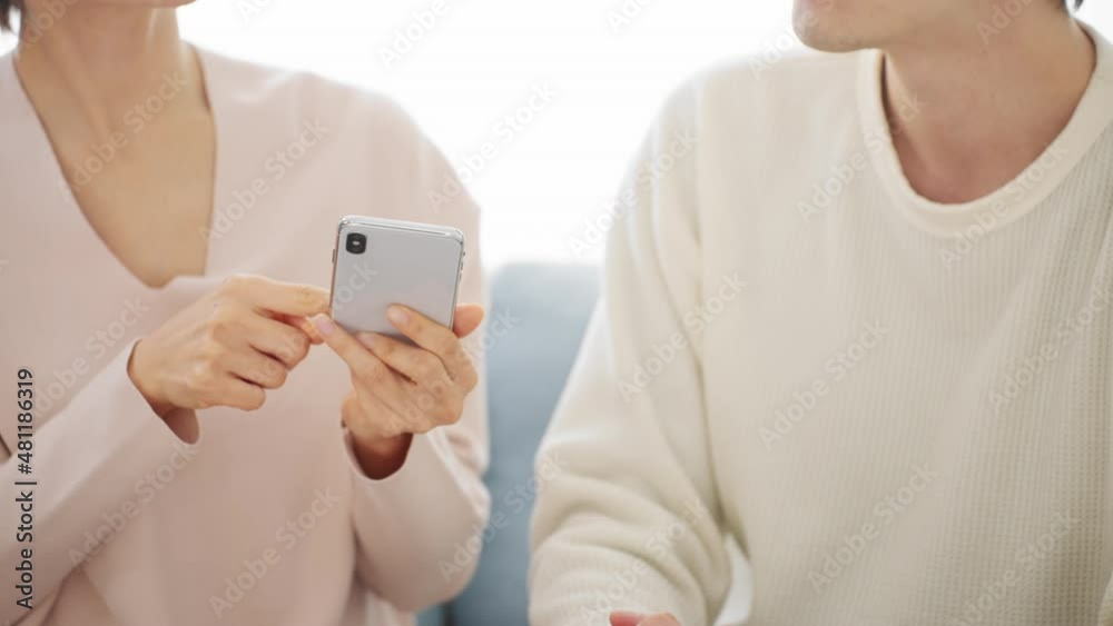 スマートフォンで調べ毎をするカップル スマートフォンで調べ毎をするカップル